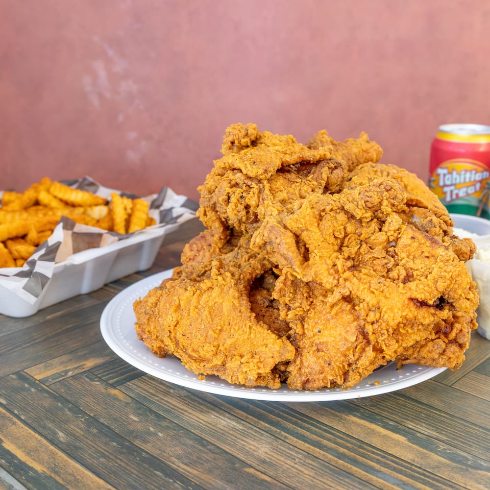 Generous serving of crispy fried chicken, crinkle-cut fries, coleslaw, and two sodas.